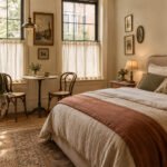 Cozy European café inspired bedroom with linen bedding, café curtains, vintage furniture, warm lighting, and bistro-style decor